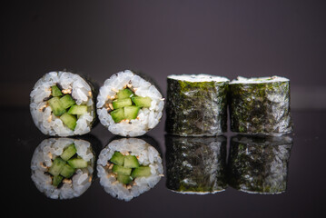 Assorted sushi rolls with salmon tuna cucumber and sesame seeds on dark background © Lemonade