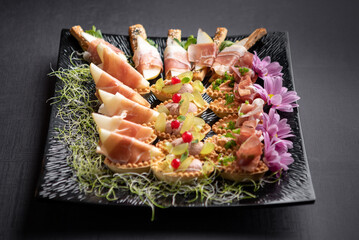 Assorted sushi rolls with salmon tuna cucumber and sesame seeds on dark background © Lemonade