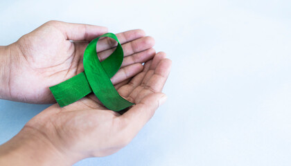 Holding Green awareness ribbon, World Glaucoma Day concept image