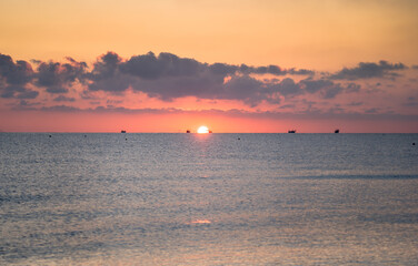 Naklejka na ściany i meble Sunset on the beach with clouds
