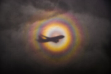 optical phenomenon called a glory, cast onto clouds below a plane in flight. circular rainbow