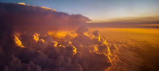 circumventing a large anvil cumulonimbus storm cloud at sunset