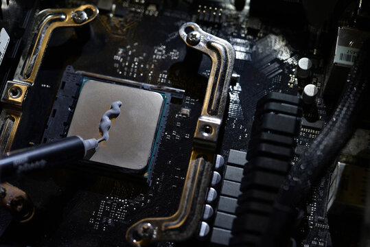 Applying thermal paste to the surface of the computer processor. Thermal interface on the processor.