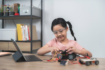 Asian littlle girl constructing and coding robot at STEM class,Fixing and repair mechanic toy car