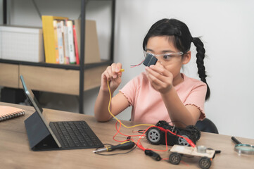 Asian littlle girl constructing and coding robot at STEM class,Fixing and repair mechanic toy car