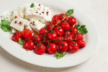 baked cherry tomatoes , with cheese, and spices, on a white plate, homemade, no people,