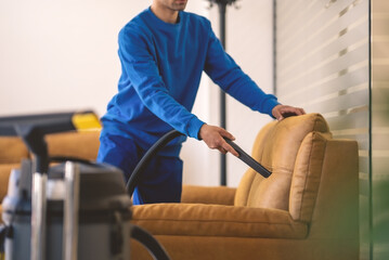 Fototapeta na wymiar Upholstery vacuming and cleaning.Cleaning furniture.Worker cleaning upholstery.