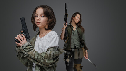 Studio shot of two female survivors with guns in post apocalyptic style.