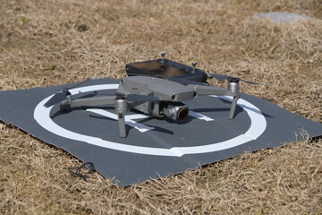 A drone sitting on landing pad outside.