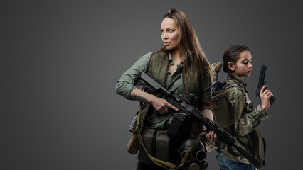 Obraz na płótnie Canvas Studio shot of two female survivors with guns in post apocalyptic style.