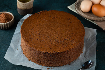 Homemade round chocolate sponge cake or chiffon cake. Sponge cake ingredients: eggs, flour and cocoa. Chocolate biscuit