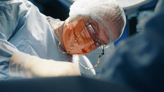 A closeup of veterinarian in glasses performing a surgery on an animal. They need to be careful and steady to not damage the animal more. High quality 4k footage. 