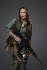 Fototapeta na wymiar Studio shot of professional killer woman with rifle in setting of post apocalypse.
