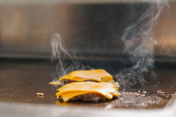 professional kitchen in hotel restaurant close up smash burger with grilled cheese food concept - obrazy, fototapety, plakaty