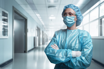 Fototapeta na wymiar Shot of surgeon woman posing with crossed arms against corridor of modern hospital.
