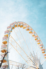 Colorful Ferris wheel in an amusement park with blue sky