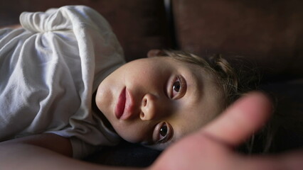 Obraz premium One tired little boy waking up from nap. Sleeping child wakes up from slomber. Small kid opening eyes lying on couch