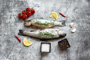 raw trout with spices on stone background