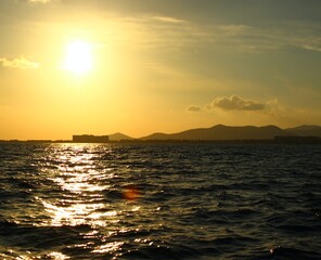 Sunrise and sunset on the sea on a sailing boat. Seagulls in the dock. Old Town of Ibiza. Best play of light on the water. Moored hulls.