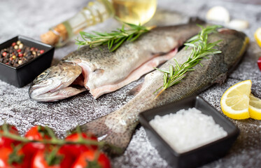 raw trout with spices on stone background