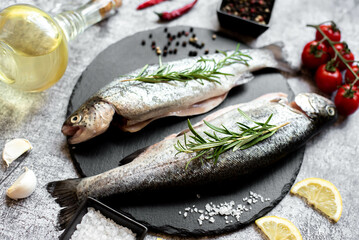 raw trout with spices on stone background