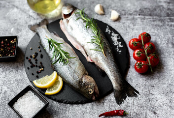 raw trout with spices on stone background