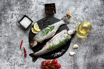 raw trout with spices on stone background