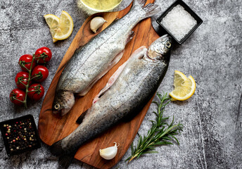 raw trout with spices on stone background