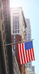 American flag with buildings in the background, selective focus, New York City, USA.