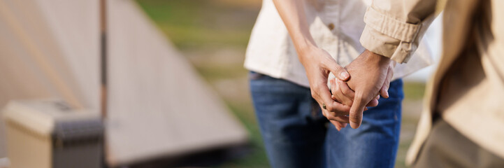 Asian couple camping outdoors. Couple travelers holding hands together love and Travel Lifestyle.