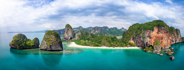 Panoramic view of the beautiful Phra Nang Cave Beach at Krabi, Thailand, with fine sand and emerald sea, corals and steep limestone cliffs