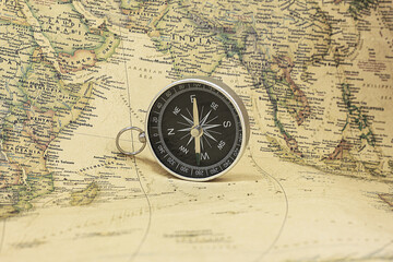 Fototapeta na wymiar Classic round compass on background of old vintage map