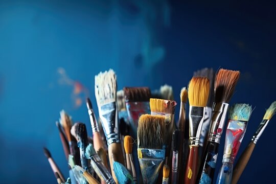  a bunch of paint brushes are in a cup on a table with a blue wall in the background and a blue wall in the background.  generative ai