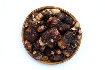 Organic taro fruit in bamboo weave plate on white background.