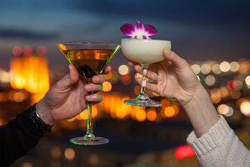 cheers with cocktails at dusk