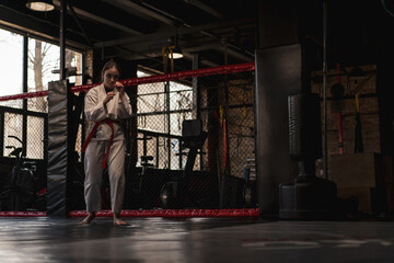 A girl practices karate in a gym A woman in kimono practices movements and poses Martial arts