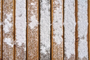 Snow on a wooden plank floor of an open terrace close-up as a background. Top view.