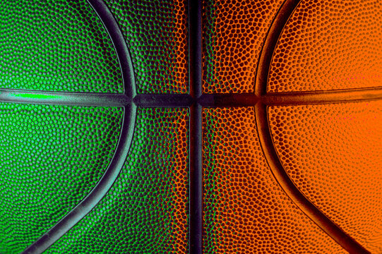 Closeup detail of basketball ball texture background. Green and orange neon. Banner Art concept
