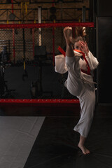 A girl practices karate in a gym A woman in kimono practices movements and poses Martial arts