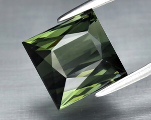 Fototapeta na wymiar Natural gem green tourmaline on gray background