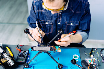 Engineer working on racing fpv drone combat kamikaze bomber in workshop.