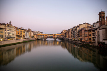 Fototapeta na wymiar View of the Ponte Vecchio on the Arno river in the middle of the city of Florence with a sky with clouds, Italy