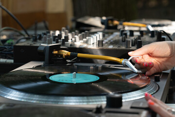 Obraz premium Female DJ playing mixing music on vinyl turntables at party