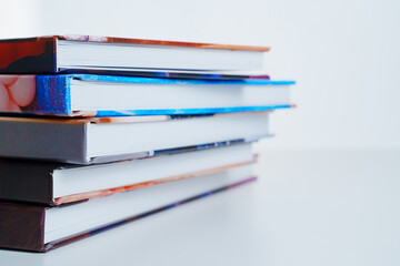 photobooks stacked on top of each other on a white table.