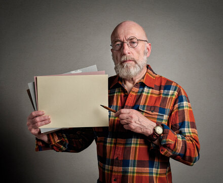 Senior Man Is Holding A Blank Sheet Of Paper And A Pen, Presentation Or Teaching Concept