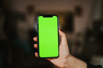 girl holding mobile phone with green screen
