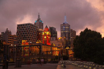 Beautiful view of the flinders railway station in Melbourne during the sunset with a purple rainy sky as a background