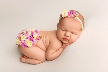 Top view of a newborn baby sleeping naked on a white felt background. Beautiful portrait of a...