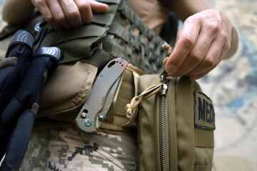 A soldier, a tactical medic opens a first aid kit, close-up view.