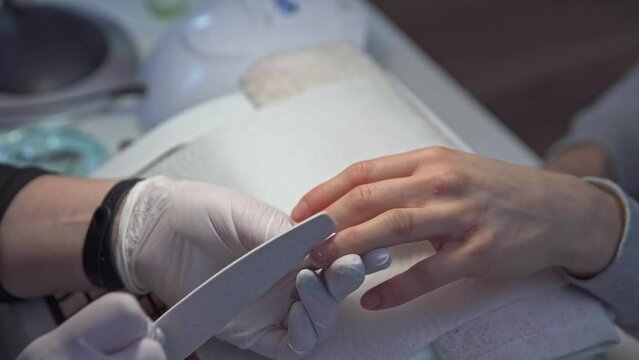 close-up of beautician and client's hands during manicure